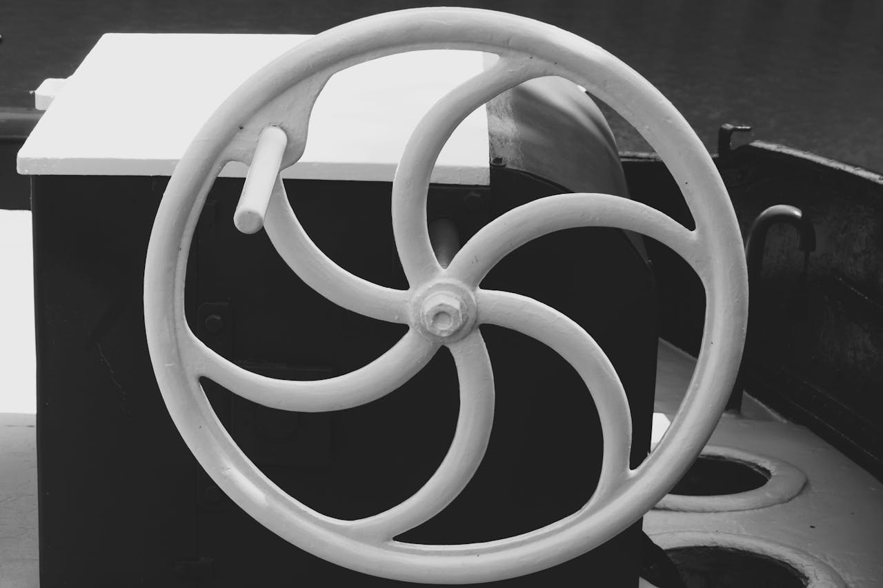 services-06 Grayscale close-up of a vintage nautical steering wheel in Gent, Belgium.